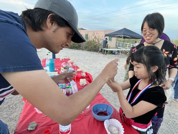 Christian shows a young girl how to isolate fruit DNA