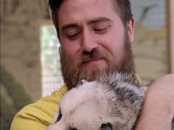 Closeup of Liam Roberts holding a possum