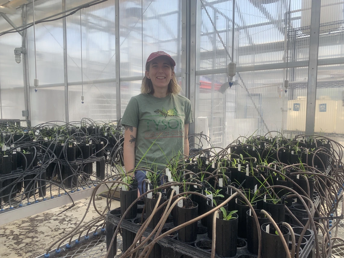 Savannah stands in front of their research project in a rooftop greenhouse.